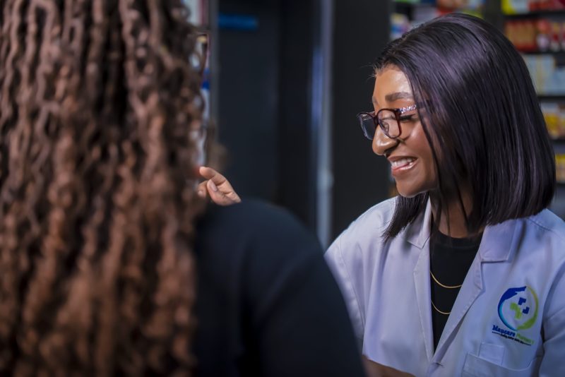 A Maucare pharmacist in conversation with a customer
